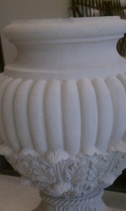White fluted urn iwth flourishes at the base